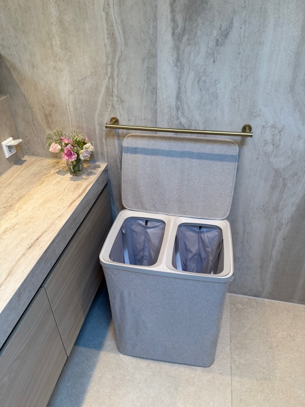 De beige wasmand heeft twee aparte vakken van elk 50 liter