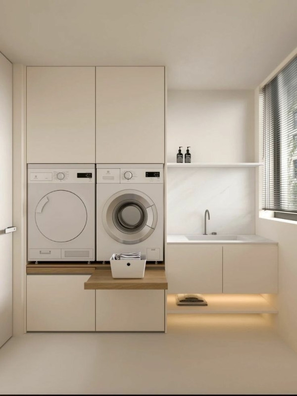 Wasmachinekast met wasmachine en droger in een moderne beige bijkeuken