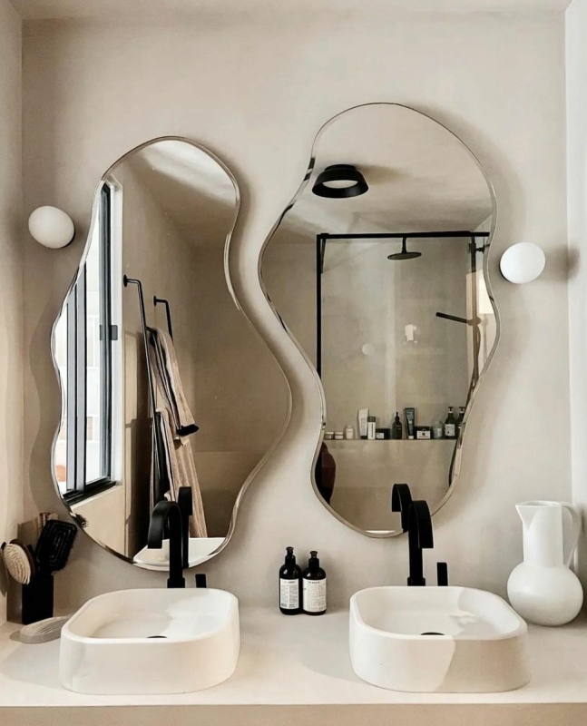 dubbele wastafel met beton ciré muren in een badkamer en organische spiegels