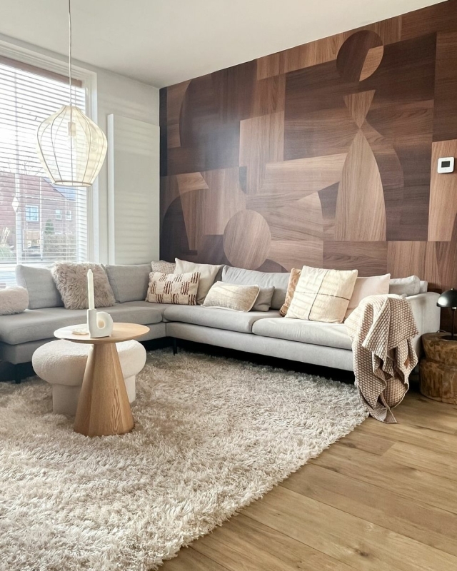 woonkamer met behang van houtprint en grijze bank
