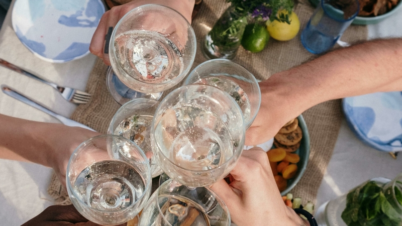 zomers tuinfeest met feestelijk gedekte tafel en mensen die glazen klinken