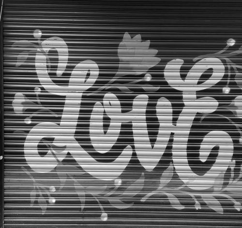 muurschildering street art tekst love en bloemen