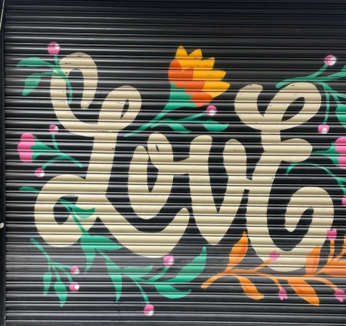 muurschildering street art tekst love en bloemen