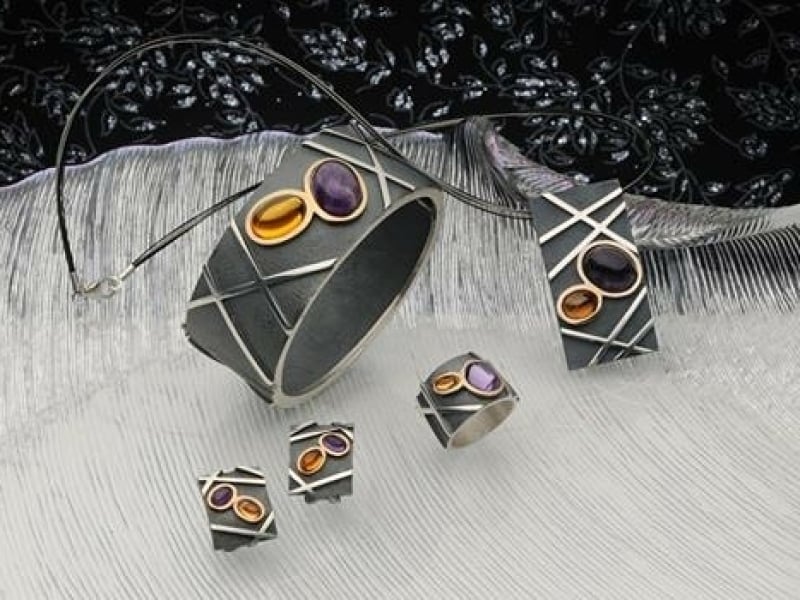 Een set zilveren sieraden met zwart oxyde en 18 krt. goud met edelstenen. Citrien en amethist
