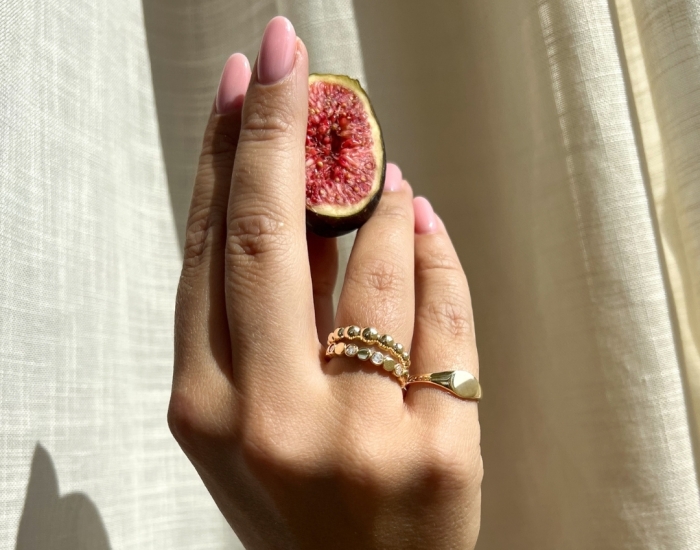 Hand met gouden ringen van Excellent Jewelry - Juwelier Leguit