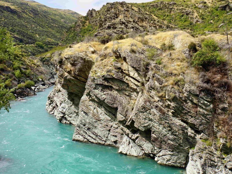Rotsformatie met helderblauwe rivier in NZ