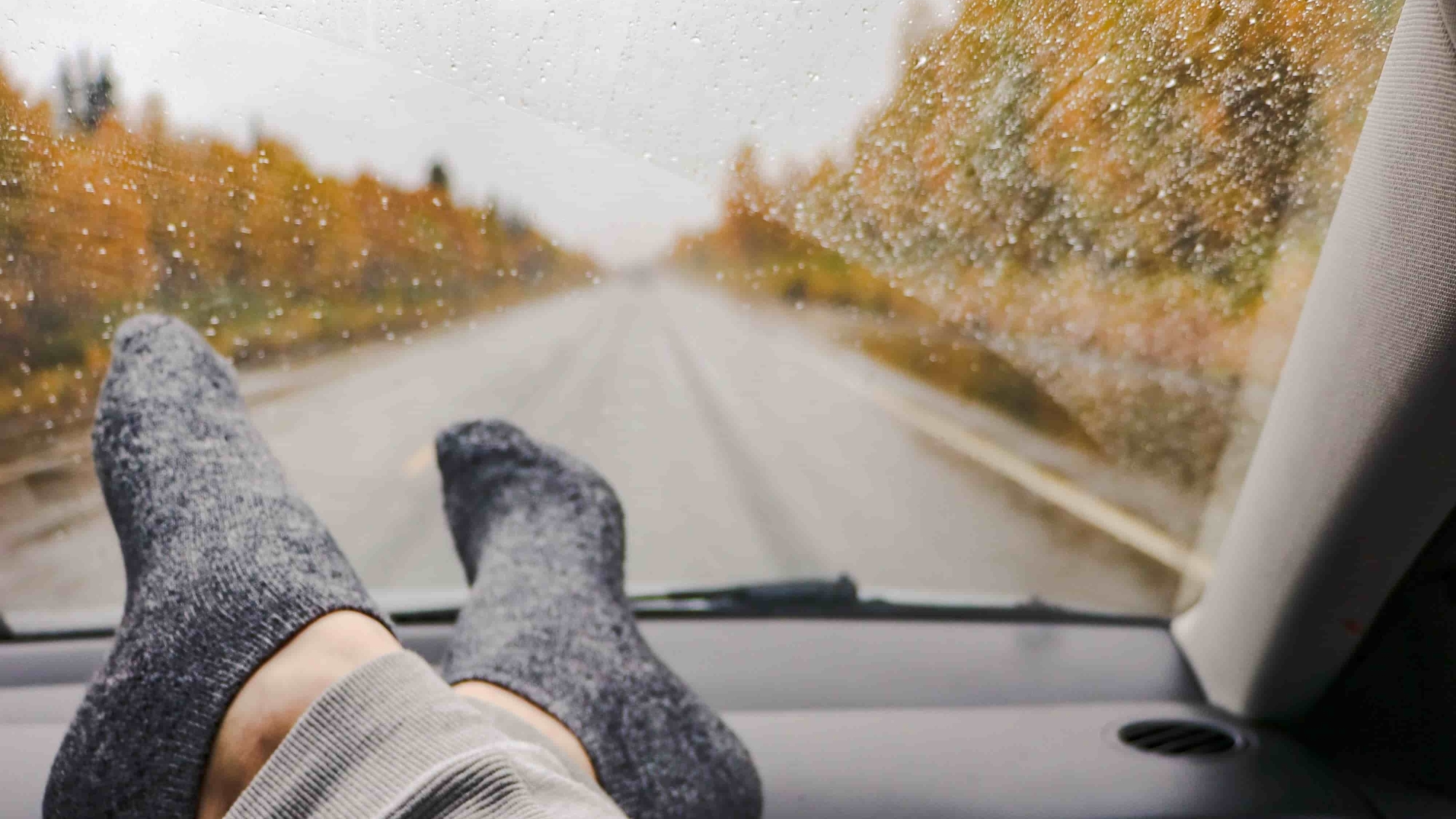 Voeten met sokken op dashboard tijdens autorit