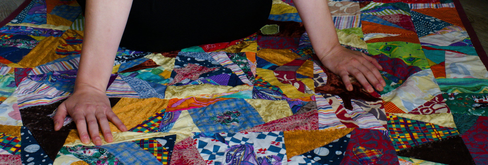 Picknick crazy quilt met armen die erop leunt Picknick crazy quilt met armen die erop leunt