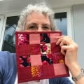 angie-hale-with her quilted coaster made with the nine patch pattern in red and pink fabrics