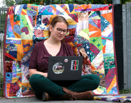 Rianne in front of picknick quilt with laptop