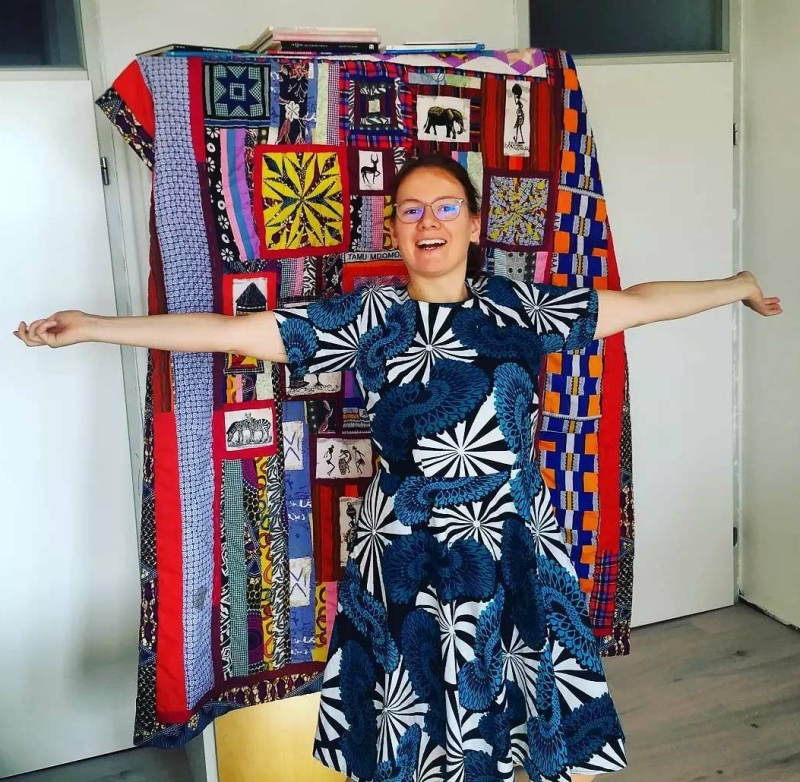 Rianne in a kitenge dress with the kenyan quilt in background