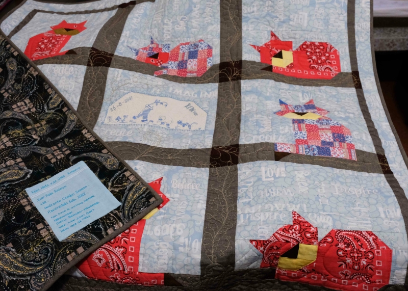 Memory baby quilt with patchwork cats and a label