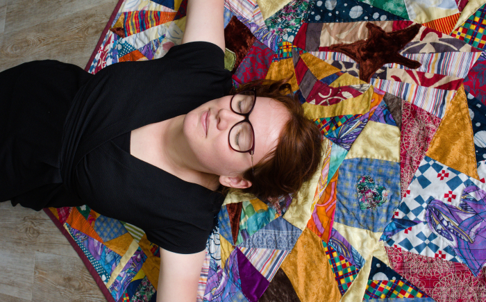 Rianne of kick-ass quilts relaxing on a crazy patchwork picknick quilt made with upcycled fabric