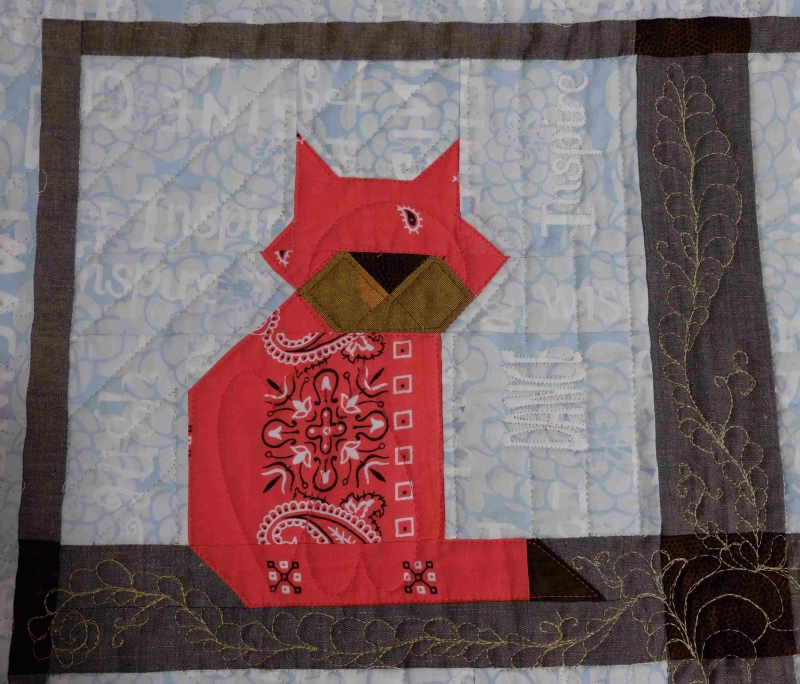 Baby memory quilt with patchwork cat made from a red farmers handkerchief