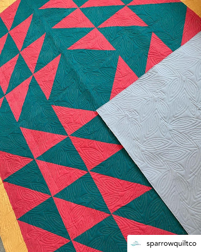 Red and green quilt by prickly pear quilting made with reclaimed fabrics