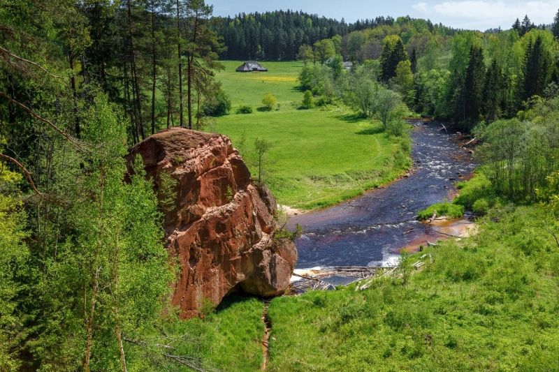 Groene vallei met rode zandsteenrotsen en de Amata rivier, een mooie plek voor natuurliefhebbers in Letland.