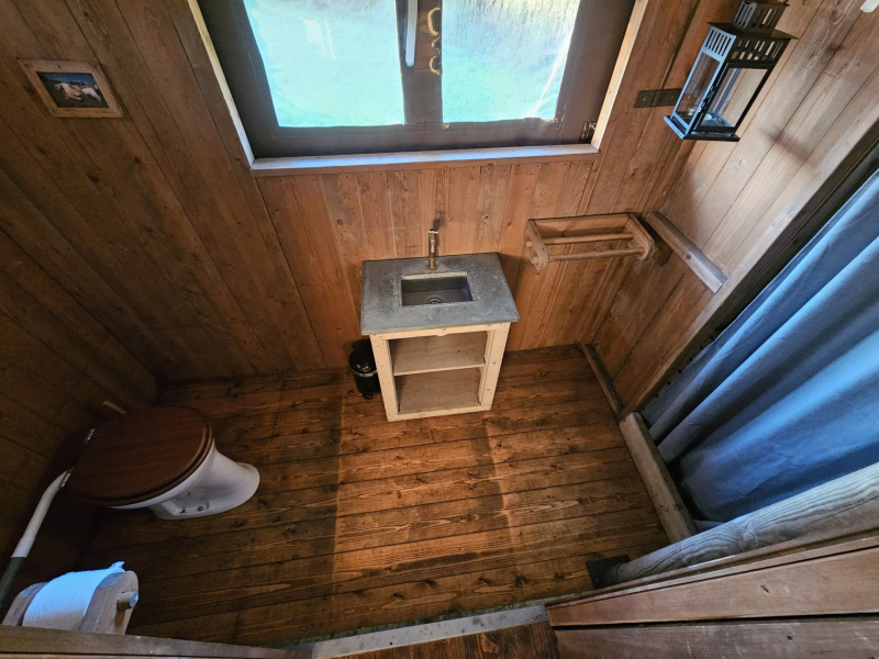 Eenvoudige badkamer met toilet en wasbak in een safaritent van BoerenBed