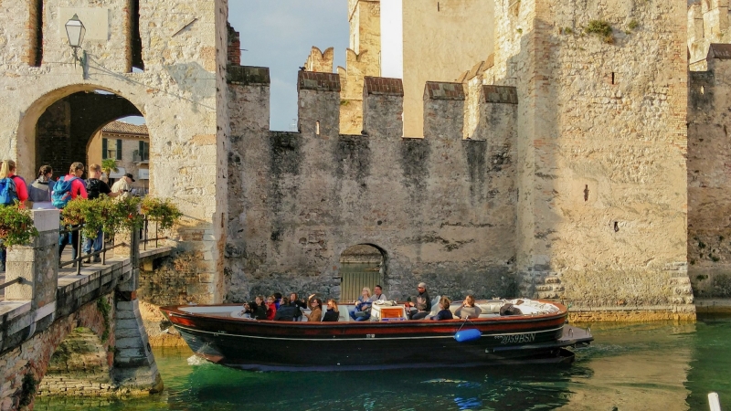 Boot met toeristen bij Castello Scaligero in Sirmione aan het Gardameer