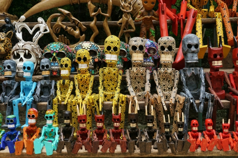 Houten souvenirs bij Chichén Itzá Kleurrijke houten beeldjes en skull souvenirs op een kraam bij Chichén Itzá.