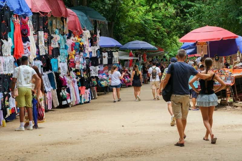 Souvenirmarkt bij Chichén Itzá Souvenirstalletjes langs het pad bij Chichén Itzá met kleding, beeldjes en bezoekers.