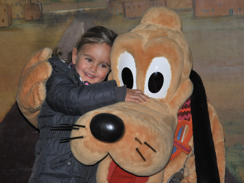 Kind knuffelt Pluto in Disneyland Parijs