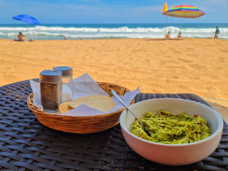 Verse guacamole met tostadas op een gevlochten tafel aan het strand van San Agustinillo bij Un Sueño Mexico