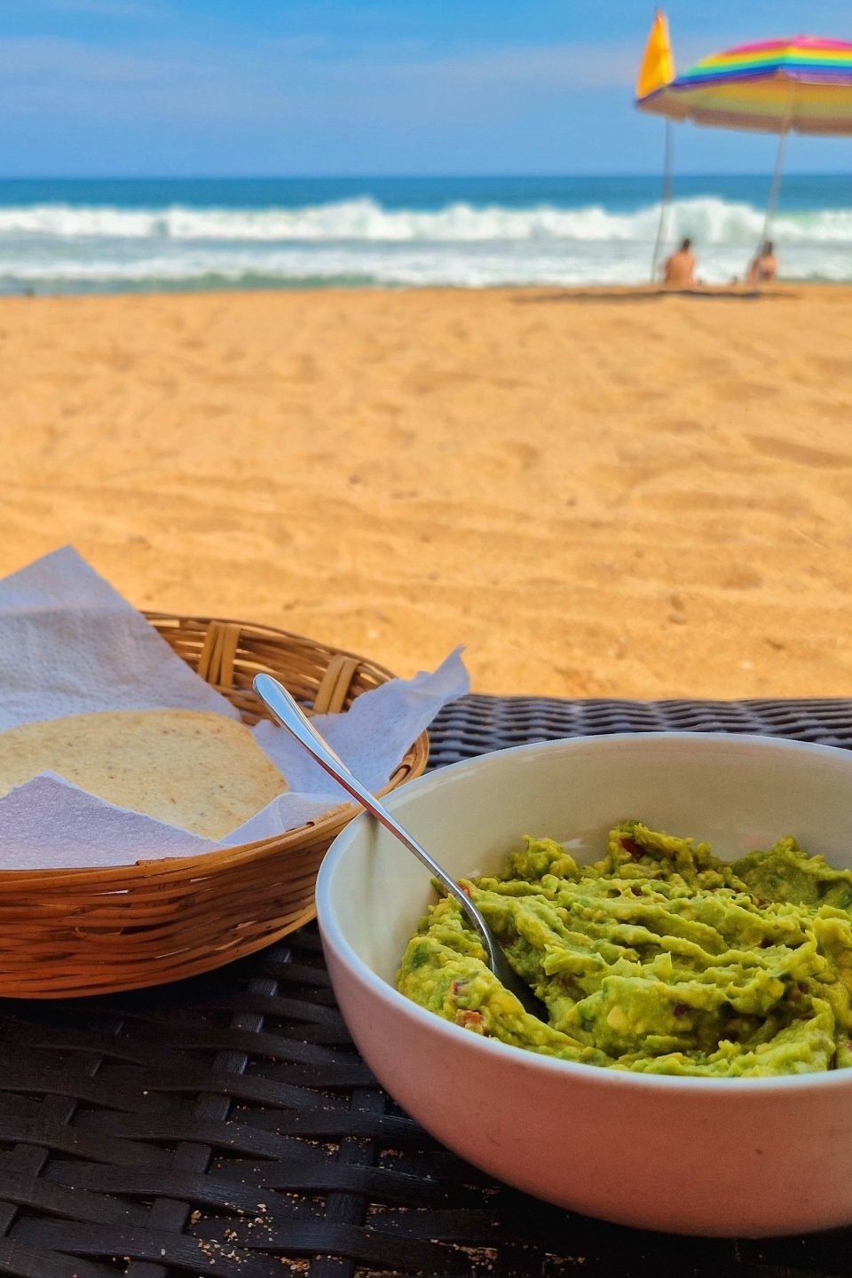 Verse guacamole met tostadas op een gevlochten tafel aan het strand van San Agustinillo bij Un Sueño Mexico