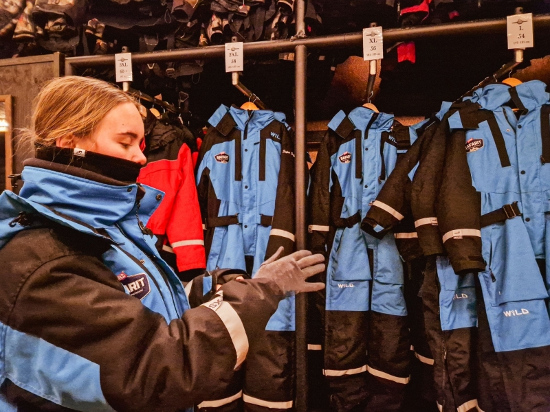 Voor vertrek passen we handschoenen en winterkleding voor de sneeuwscooter safari in Tahko