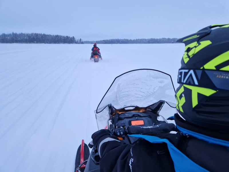 POV vanaf de sneeuwscooter op een bevroren meer in Tahko met de gids voor ons
