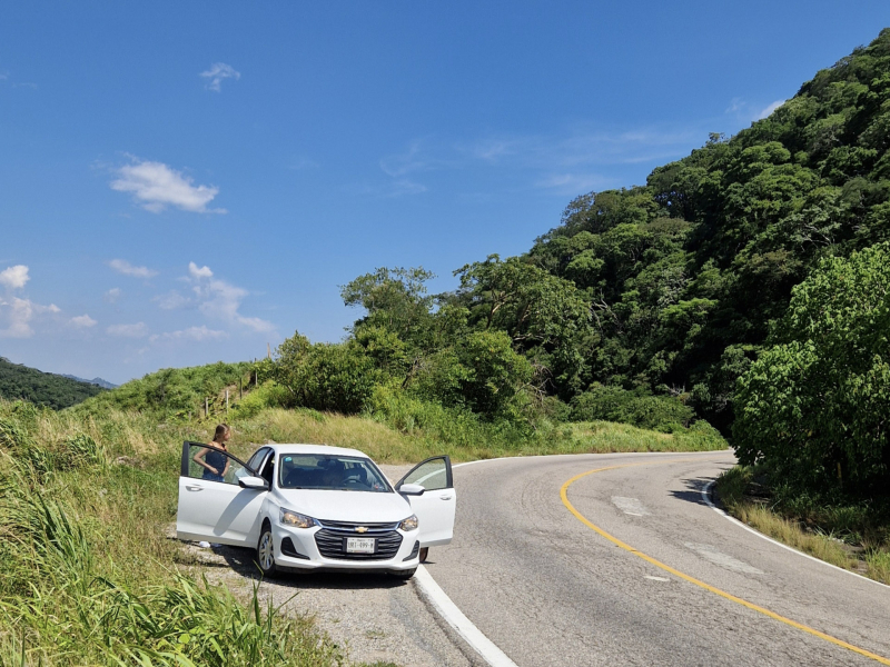 Rechte weg door groen landschap in Yucatán met bergen op de achtergrond