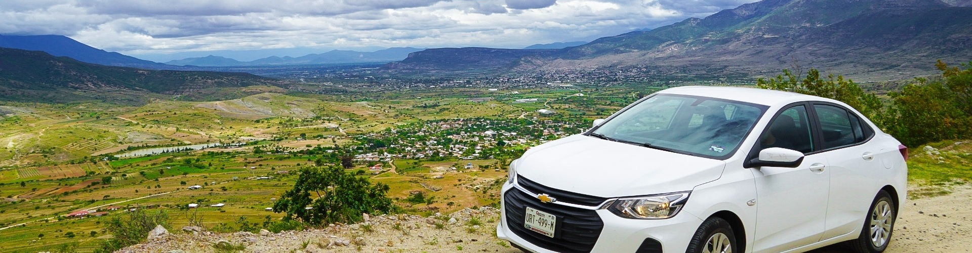 Roadtrip Mexico met huurauto Witte huurauto met uitzicht over berglandschap tijdens een roadtrip in Mexico