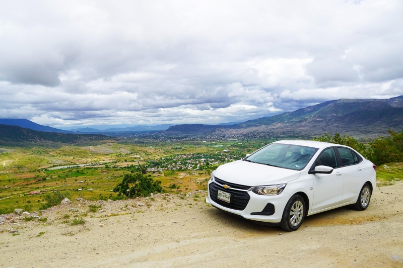 Witte huurauto met uitzicht over berglandschap tijdens een roadtrip in Mexico