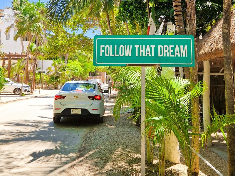 Straat in Tulum met bord Follow That Dream tijdens een roadtrip in Mexico met huurauto