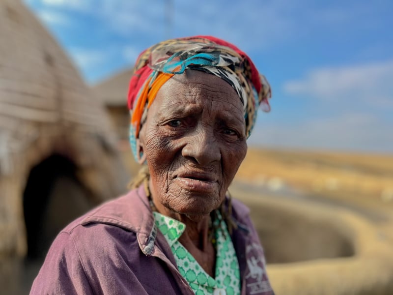 Vrouw bij traditioneel Zulu huis