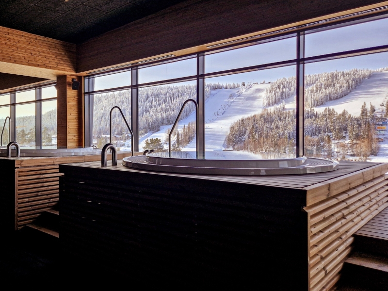 Verwarmd bubbelbad in de wellness van Break Sokos Hotel Tahko met uitzicht op de verlichte skipistes