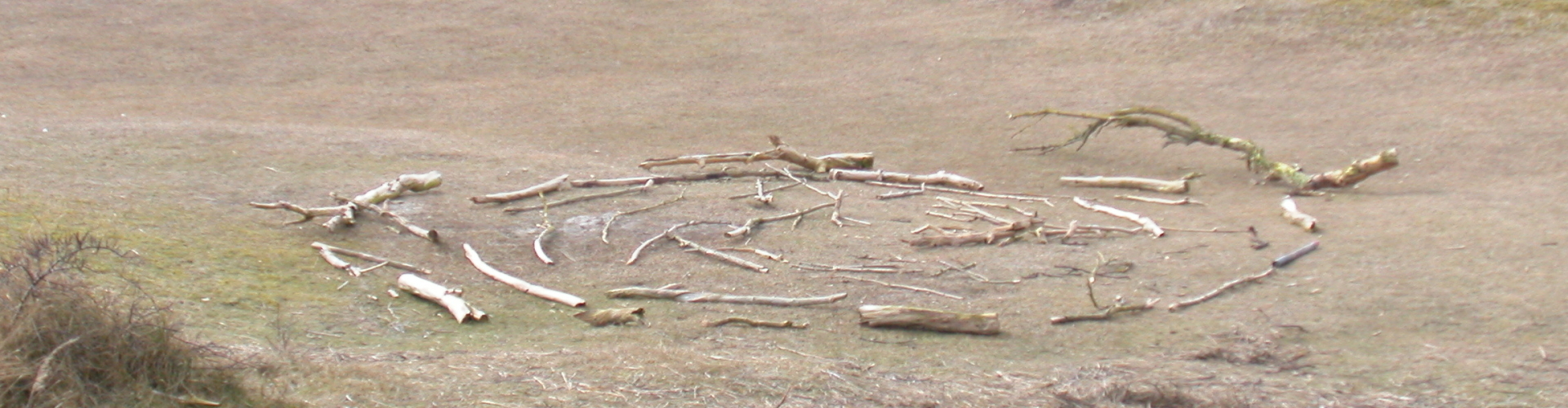 een cirkel gemaakt van takken als een slakkenhuis neergelegd midden in de duinen