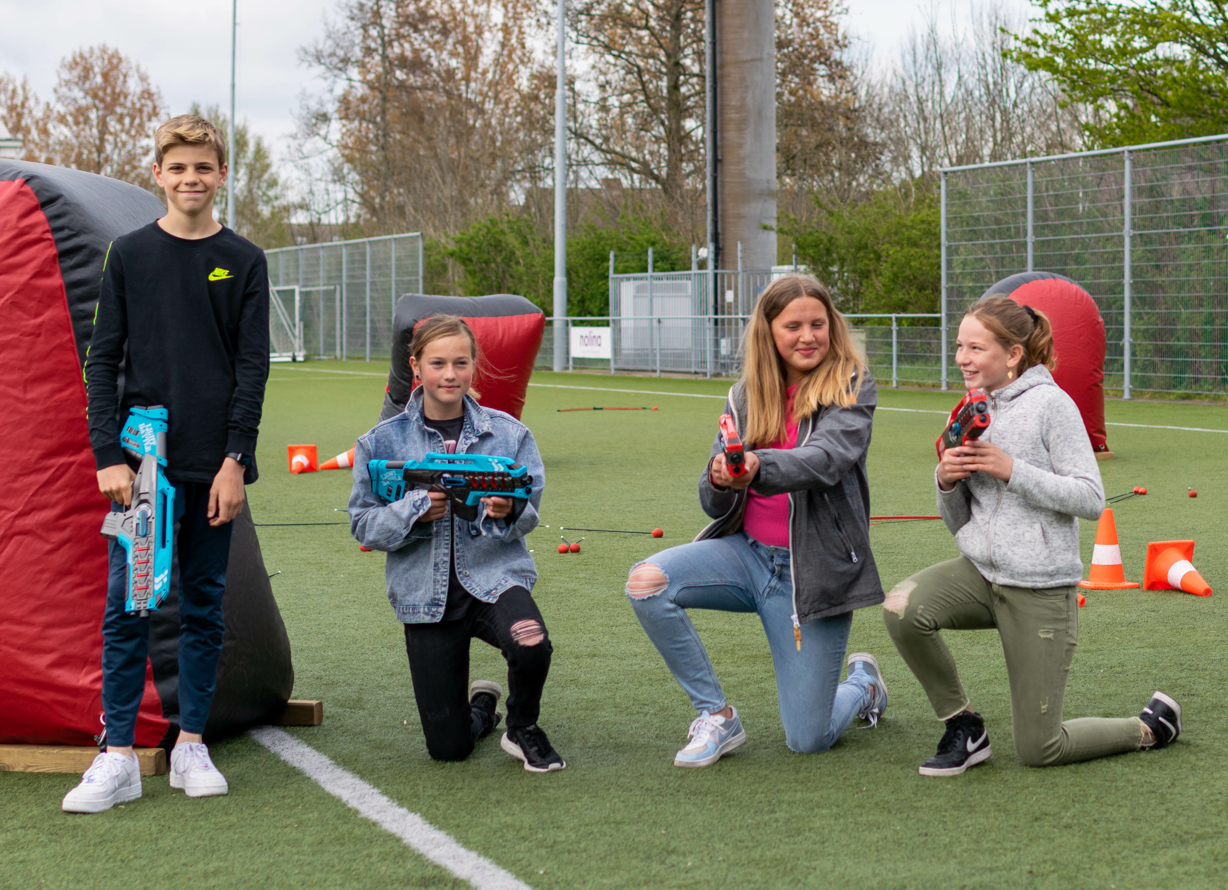 Kinderen spelen outdoor lasergame op een sportveld in Eindhoven