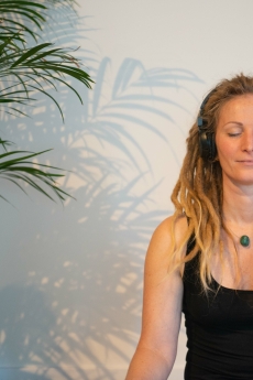 Marjolein luistert meditatie met koptelefoon op