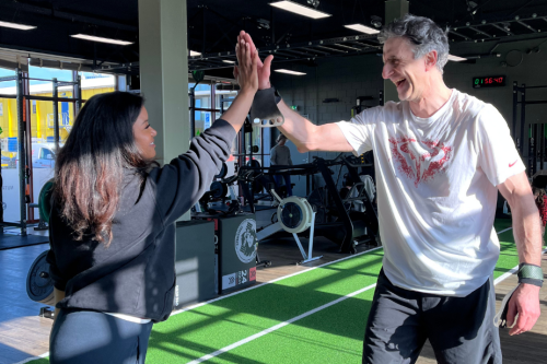 Sporters rennen over het zand terwijl ze verschillende oefeningen afwerken tijdens een energieke bootcamp training in Scheveningen.
