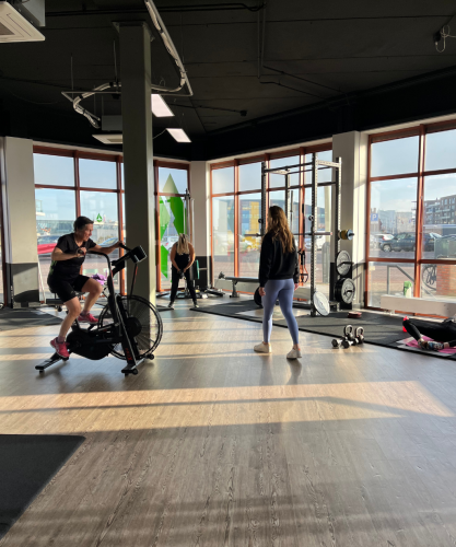 Deelnemers voeren simpele oefeningen uit met hun eigen lichaamsgewicht tijdens een actieve bootcamp les aan zee in Scheveningen.