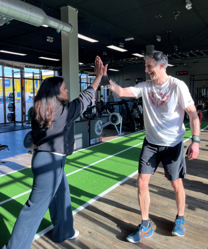 Sporters rennen over het zand terwijl ze verschillende oefeningen afwerken tijdens een energieke bootcamp training in Scheveningen.