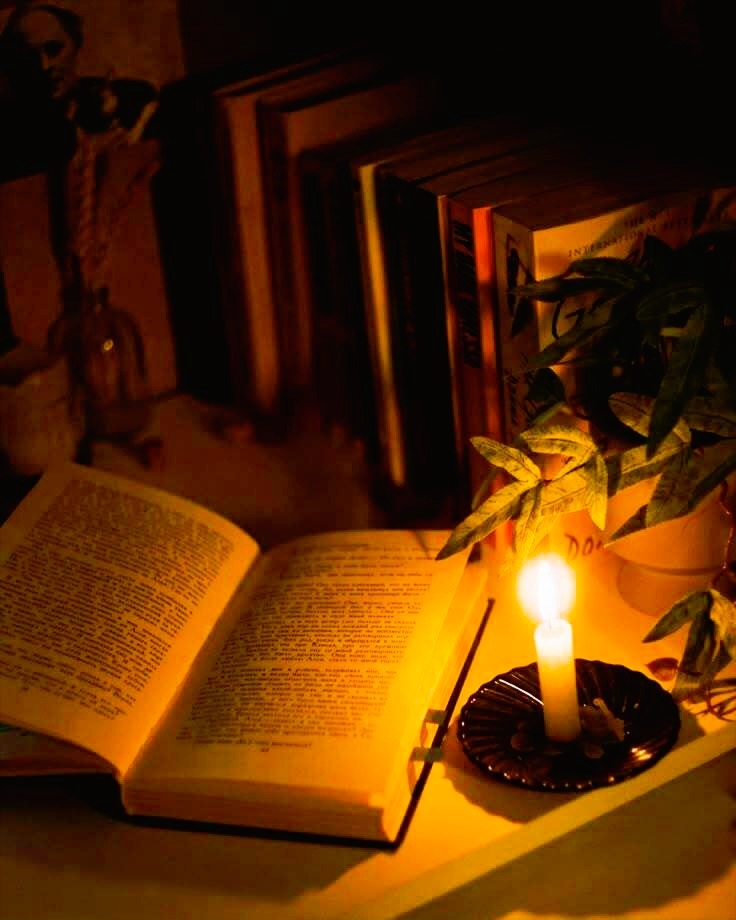 Boek en kaars op tafel als beeld van de ontmoeting tussen wetenschap en spiritualiteit bij familielijnen