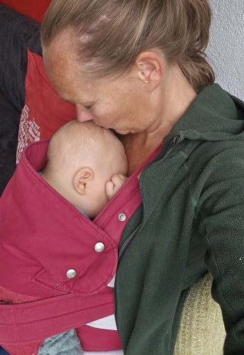 Maaike draagt haar baby ergonomisch in een draagdoek tijdens een draagconsult
