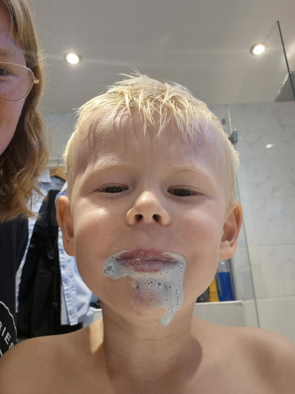 Schuim wordt blauw bij lang genoeg poetsen Jongetje van 4 die heeft gepoetst met Elmex kleurveranderende tandpasta