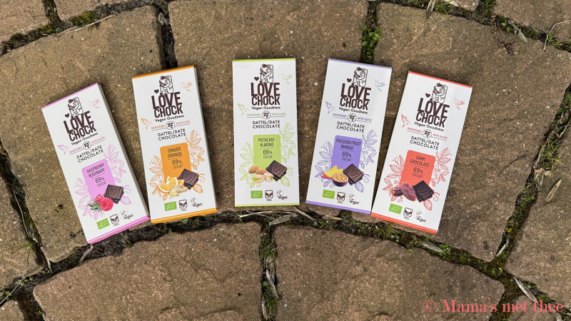 Verschillende smaken Lovechock chocolade, in een lichte ronding uitgestald op een cirkelvormig terras met roze tegels.