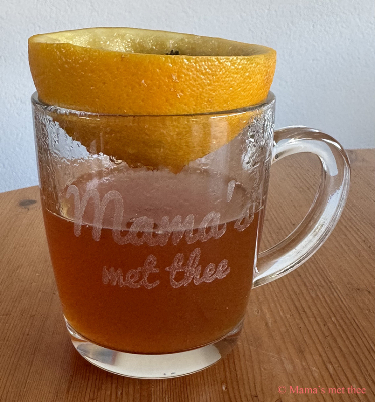 Kopje sinaasappelthee met verse sinaasappel en sinaasappel als filter