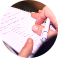 Hand, notitieblok en stylo tijdens jaarbegeleiding van marketingplanner
