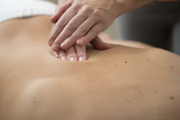 Flow-massage – zachte aanraking en ontspanning bij Massagepraktijk Elzinga Hand die met zachte aanraking over de rug beweegt tijdens een Flow-sessie, gericht op ontspanning, herstel en bewustwording.