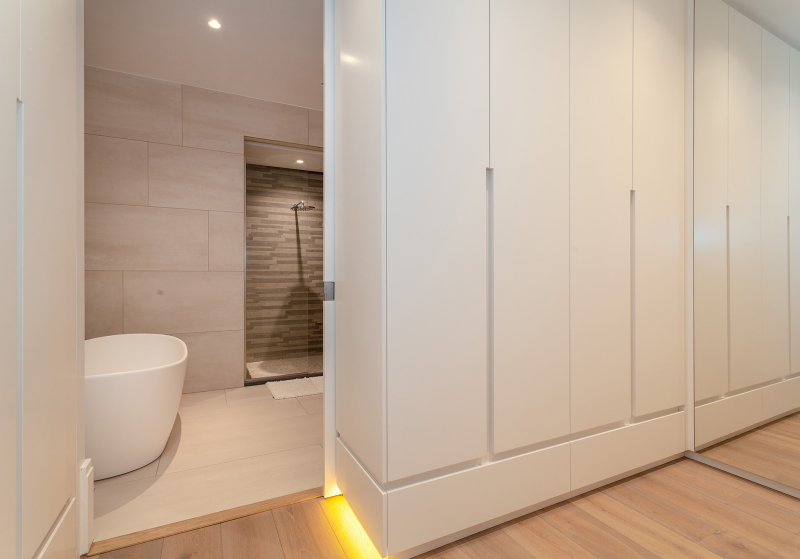Walk-in closet met maatwerk dat beweging van de toren opvangt, bijna onzichtbare speling