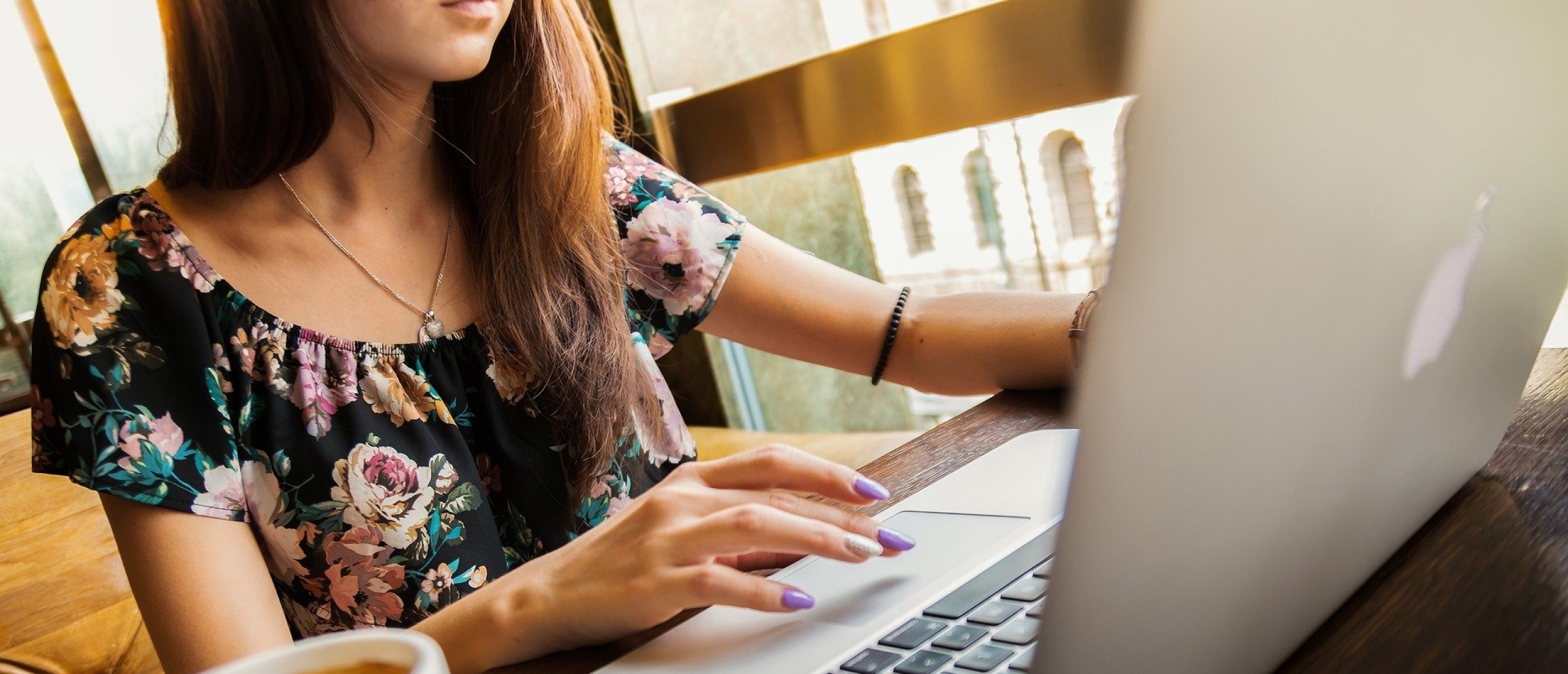 vrouw werkt op de laptop met kop koffie